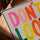 Don't Look Back canvas with multicolor lettering in light oak frame on table