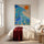 Abstract blauw canvas met golfmotief en oranje zon in modern maatwerkinterieur