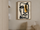Tableau abstrait représentant un visage aux lignes noires et touches ocre dans une chambre minimaliste beige.