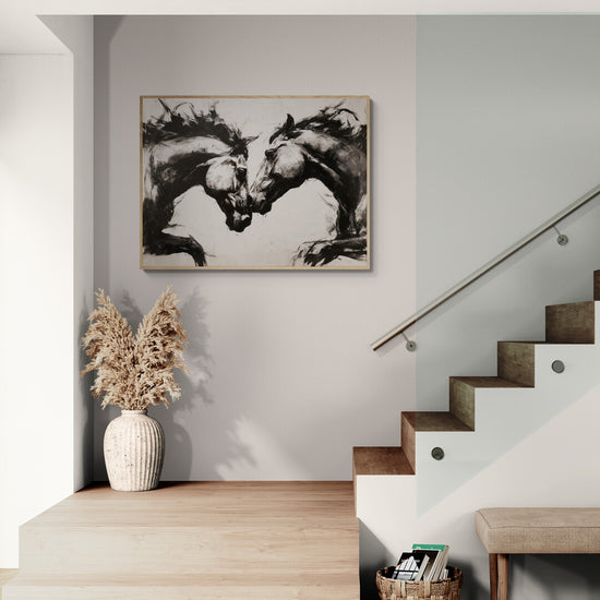 Wall art of inked black horses in a duel, modern and minimalist ambiance in an elegant foyer.