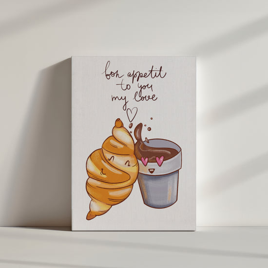 Une illustration d'un croissant et d'un chocolat chaud qui se font un câlin. Une inscription est écrite au-dessus : " bon apetit to my love".