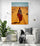 "Woman in the Desert" hangs in a minimalist living room, reading nook, white chair.