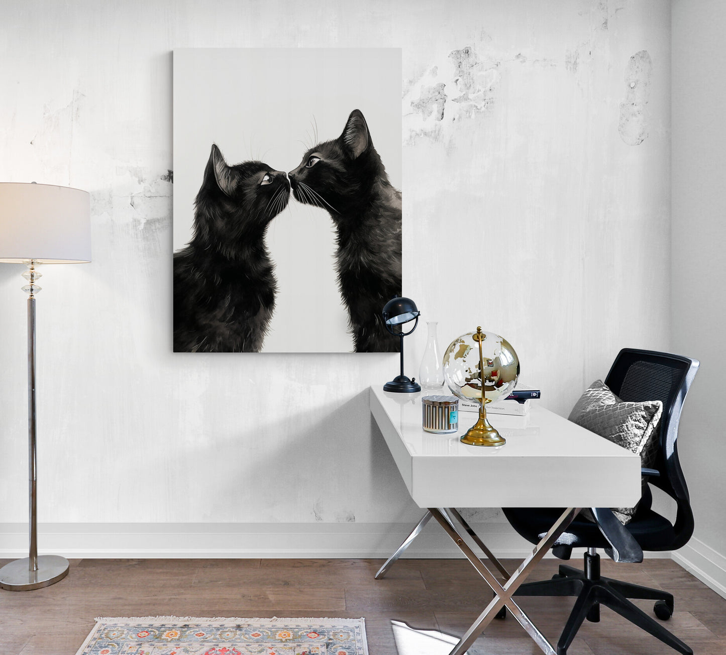 Une œuvre artistique représentant deux chats noirs se fait remarquer dans un bureau blanc, aux côtés d'un globe et d'une lampe design.