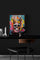 Small colorful skull canvas stands out against a black wall in a dark, modern office