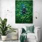  Une toile d'un paysage verdoyant est accrochée au mur d'un salon, à côté d'un canapé blanc drapé d'un plaid vert, en harmonie avec les plantes vertes environnantes, créant un espace de vie apaisant et frais.