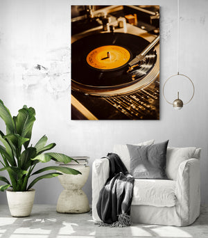 Retro vinyl art print hanging in a cozy living room with a white armchair