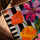 Leinwand auf Keilrahmen mit bunten Blumen, Eichenrahmen in Goldbraun auf Tisch, türkiser Hintergrund