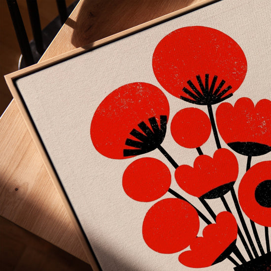 Leinwandbild mit stilisierten roten Blumen und schwarzer Vase – modernes, minimalistisches Kunstwerk im Wohnzimmer mit honigfarbenem Eichenrahmen