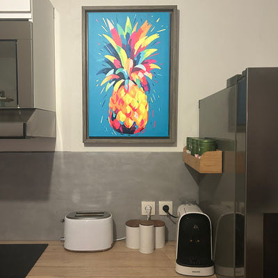 Avis client : tableau coloré représentant un ananas dans un style pop art accroché dans une cuisine moderne, ajoutant une touche vive et joyeuse à l’espace.
