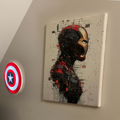 Avis client : tableau moderne d’Iron Man en profil, dans un style digital futuriste, accroché dans une chambre à l’ambiance geek avec un bouclier lumineux de Captain America fixé au mur.