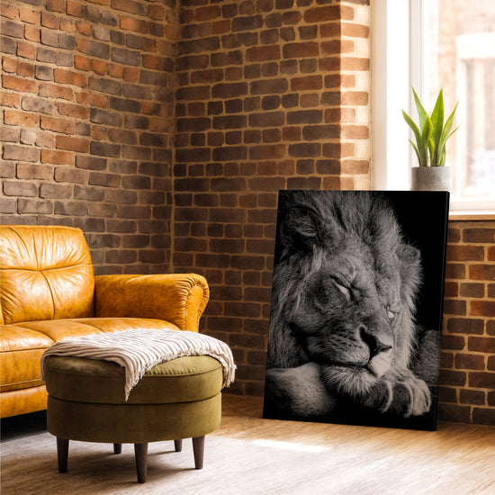 Tableau lion majestueux noir et blanc photo réaliste pour salon avec mur brique et fauteuil cuir camel