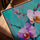 Tableau fleurs orchidées roses et blanches fond turquoise texturé sur table salon moderne cadre chêne doré