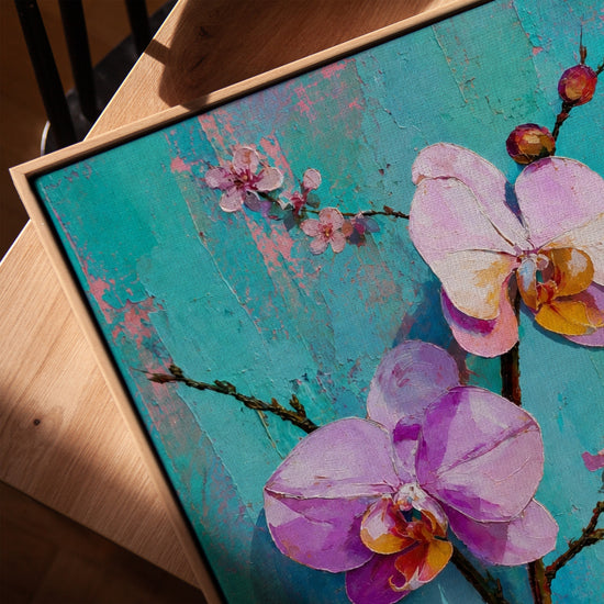 Tableau fleurs orchidées roses et blanches fond turquoise texturé sur table salon moderne cadre chêne doré