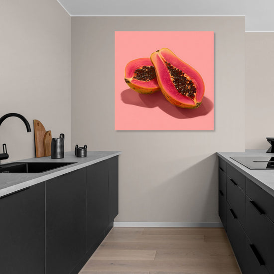 Sliced papaya wall art print on pastel pink background in a modern minimalist kitchen