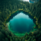 magnifique photographie aérienne d'un lac turquoise en forme de cercle, entouré d'une dense forêt d'arbres verts. Les eaux calmes du lac reflètent les arbres et le ciel, créant un miroir naturel