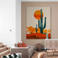 Grand tableau de cactus au centre d'un salon épuré, avec canapé gris et accessoires bohèmes.
