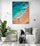 Beach wall art suspended above a white chair, creating a serene and intimate atmosphere