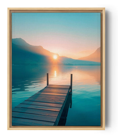 Fotografía que representa un puente de madera que se extiende sobre un lago en calma, captando la luz apacible del amanecer. La imagen desprende una atmósfera serena y relajante.