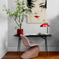 Bureau minimaliste avec tableau de geisha, plante en fleurs et lampe rouge.
