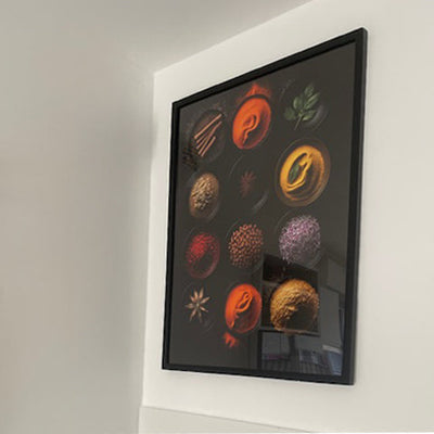 Customer review: framed kitchen wall art featuring an elegant composition of colorful spices on a black background, styled in a bright room for a warm, gourmet touch.