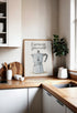 Humorous poster showcasing an Italian coffee maker with the words "Espresso Yourself," sitting on a wooden countertop in a bright Scandinavian kitchen, decorated with white bowls and a green plant.