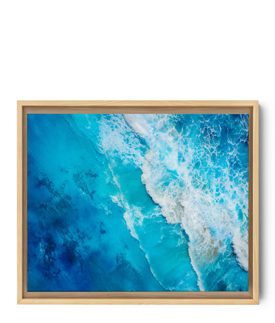 Luftaufnahme eines aufgewühlten Meeres, in dem die weißen Wellen mit dem tiefen Blau des Wassers kontrastieren. Die detaillierte Textur und die lebendigen Nuancen erzeugen ein Gefühl von Bewegung und Frische. Perfekt für eine beruhigende und immersive Wanddekoration.