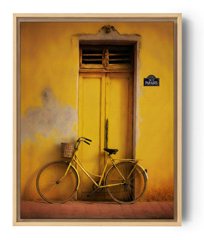Retro gele fiets tegen een zonnige gevel, mediterrane sfeer.