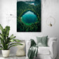 Photo d'une forêt émeraude encadrant un lac turquoise, mise en scène dans un salon épuré avec un canapé blanc moelleux, une plante verte volumineuse et une suspension design.