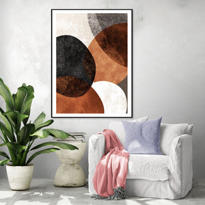 Tableau abstrait aux cercles superposés marron et noir, style moderne, dans un salon cosy avec plante verte