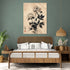 Asian floral art in black and beige on a green wall in a bohemian natural bedroom