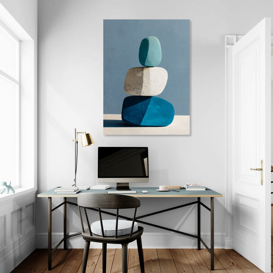 Tableau mural minimaliste de galets empilés dans un bureau moderne, couleurs bleu et beige apaisantes