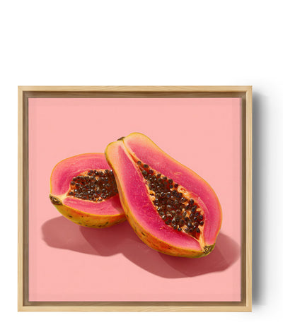 Halbierte Papaya auf pastellrosa Hintergrund, tropische und farbenfrohe Stimmung