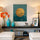 Tableau mural zen avec soleil doré sur fond bleu et silhouettes d’oiseaux, décorant un intérieur moderne et apaisant.