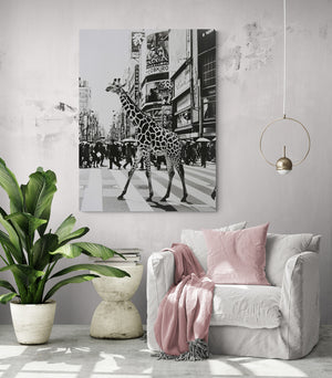 pièce de vie, fauteuil confortable, coussin et plaid rose pâle, table d'appoint, plante verte, lumière en suspension, grand tableau girafe noir et blanc.