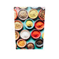 un tableau plexiglas avec une photo qui représente une photo. Sur la photo une table bleu turquoise avec des petits bols remplis d'épices culinaires, Des épices jaunes, rouges du sel, de l'anis étoilé et des autres herbes dispose en colonne.v