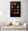 Black kitchen artwork with a photo of colorful spices hanging on a white wall above a dining nook.