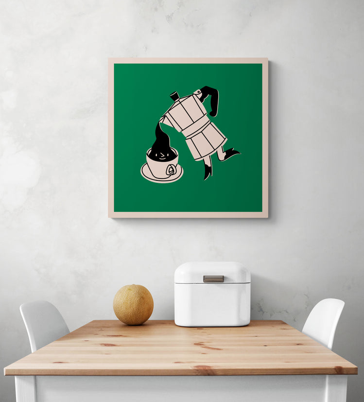 Un tableau pour cuisine vert accroché sur le mur blanc. Ce tableau cuisine est placé au-dessus d'une table en bois et deux chaises sont de chaque côté. Une boîte à pain en métal blanc et un melon sont sur la table