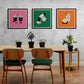 Dans une salle à mangé épuré au ton gris trois cadres colorés, orange, rose, et vert sont accrochés sur le mur. Une table et deux chaises en bois sont sur l'image 