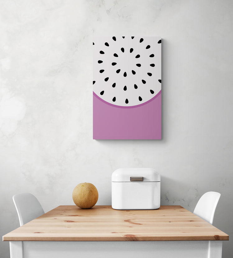 Un tableau toile cuisine est suspendu sur le mur blanc, avec des couleurs vives, du violet et du blanc. En dessous du tableau murale se trouve une table et deux chaises blanches. Sur la table se trouve une corbeille à pain en métal blanc et un petit melon. Tous ces éléments créent un look frais et coloré dans la pièce.