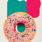 Tableau pour cuisine d'un donut dessiné à la main. Crème de couleur rose et est parsemée de pépites multicolores. L'arrière-plan du tableau est composé de deux traces de peinture, un beau rouge et l'autre verte, qui ajoutent de la profondeur et de la dimension à l'ensemble. Le tableau est très esthétique et aux couleurs vives. Minimaliste, ce tableau dégage une touche de fraîcheur et de féminité combinée au donut qui ajoute vie et gourmandise