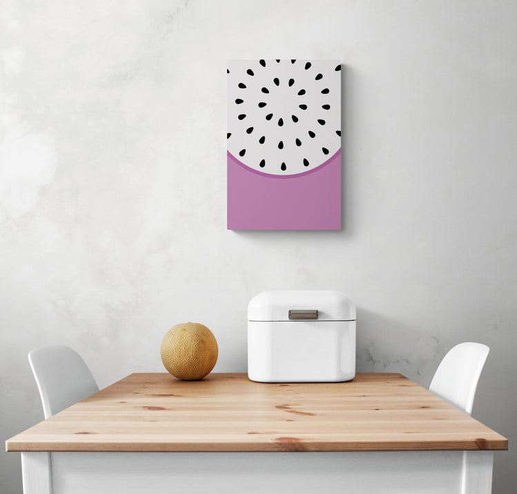 Un tableau coloré pour cuisine est accroché sur le mur blanc, avec des couleurs vives, du violet et du blanc. En dessous du tableau de fruits se trouvent une table en bois et deux chaises blanches. Sur la table se trouvent une corbeille à pain et un petit melon. Tous ces éléments créent un look frais et harmonieux dans la pièce.