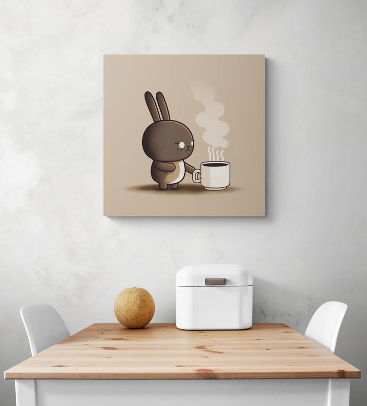 Tableau de taille moyenne, accroché sur le mur d'une cuisine au style japonaise et minimaliste. Un lapin marron malicieux, le regard figé par la douleur a été pris au dépourvu par la chaleur de la tasse de café qu'il tente de saisir. Aux couleurs taupe, la scène humoristique apporte de la vitalité