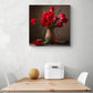 tableau deco fleur rouge est accroché sur un mur blanc au-dessus d'une table de cuisine en bois